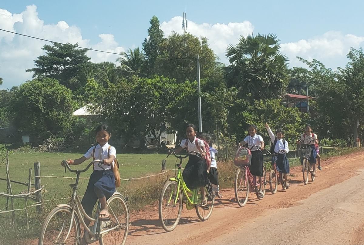 Cambodian School Children sharing donated bikes to travel to/from school